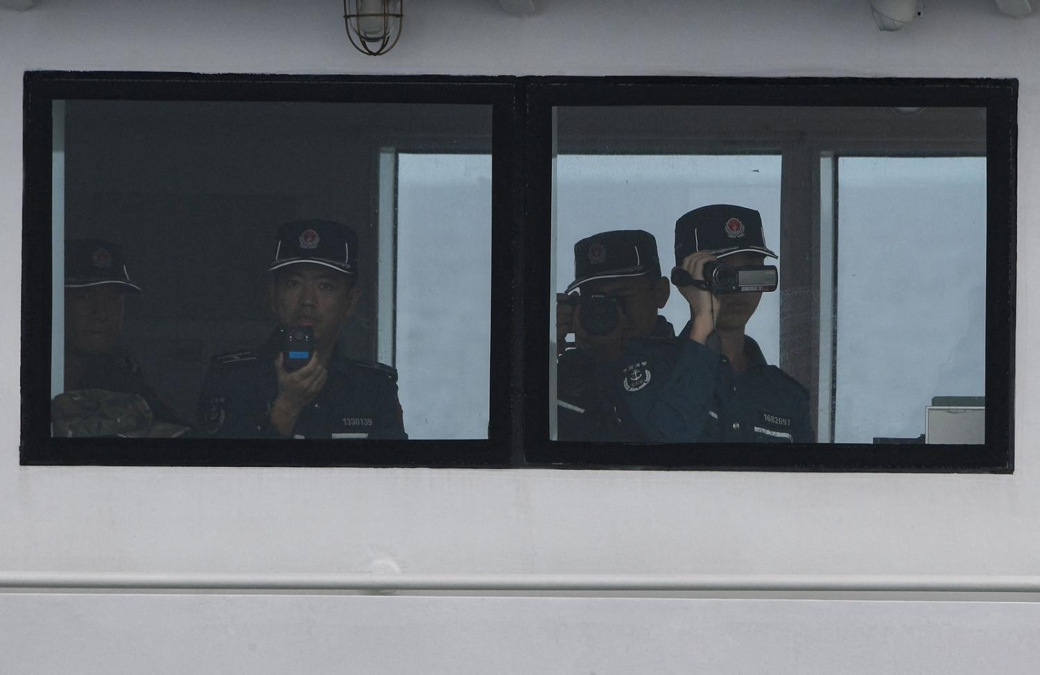 Chinese coast guards observe a civilian boat delivering supplies to Philippine navy ship BRP Sierra Madre in the disputed South China Sea (Ted Aljibe/AFP via Getty Images)